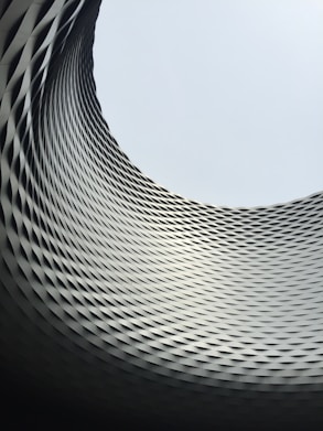 curved building wall in grayscale photography