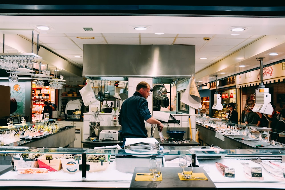 man in blue shirt behind the counter