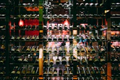 Sophisticated wine cellar with rows of neatly stacked dark glass bottles and ambient lighting.