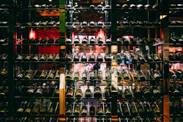 Sophisticated wine cellar with rows of neatly stacked dark glass bottles and ambient lighting.