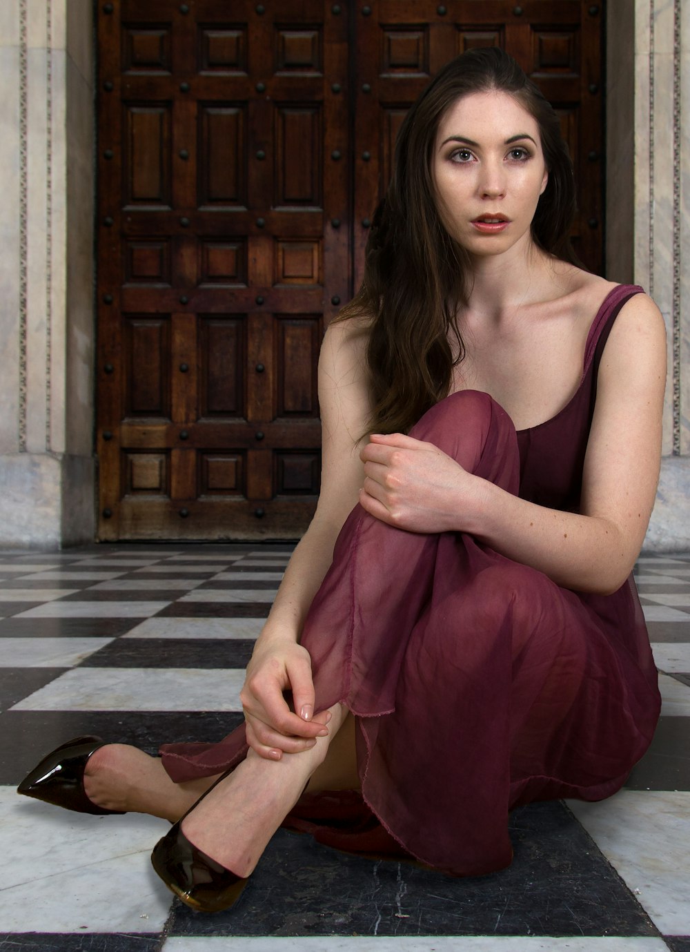 woman in burgundy dress sits on the floor