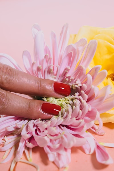 Fingers rubbing a pink flower