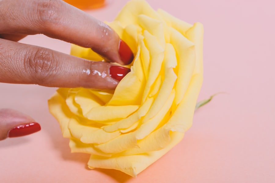 Two fingers inserted in the middle of a flower. 