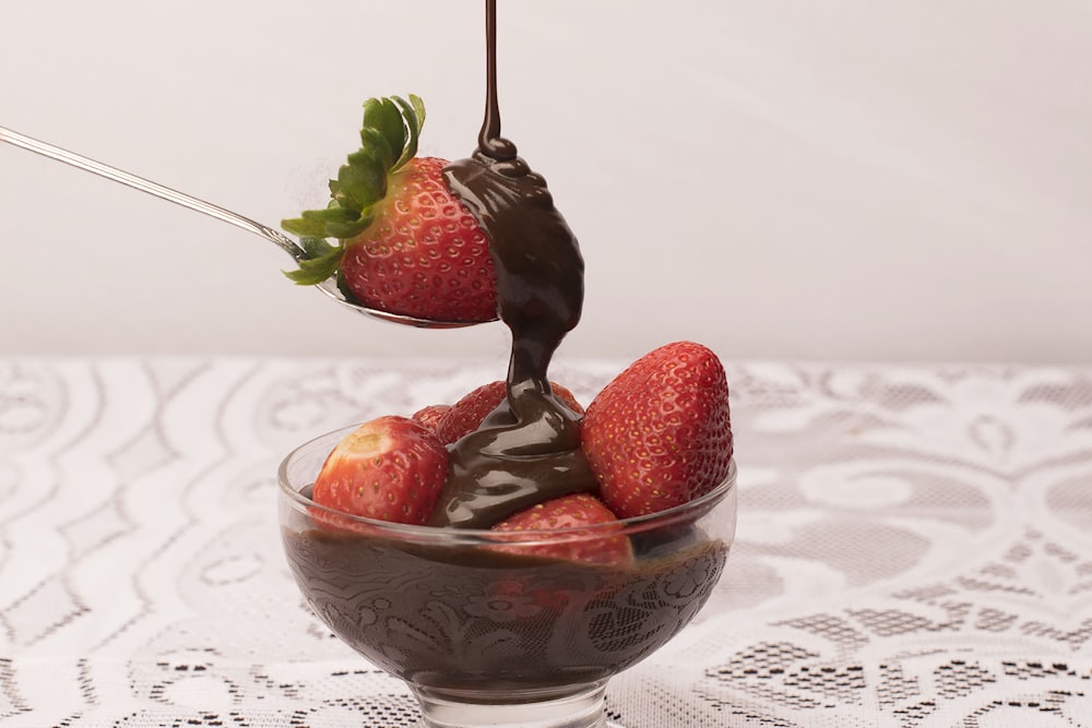 red strawberries with chocolate syrup on bowl