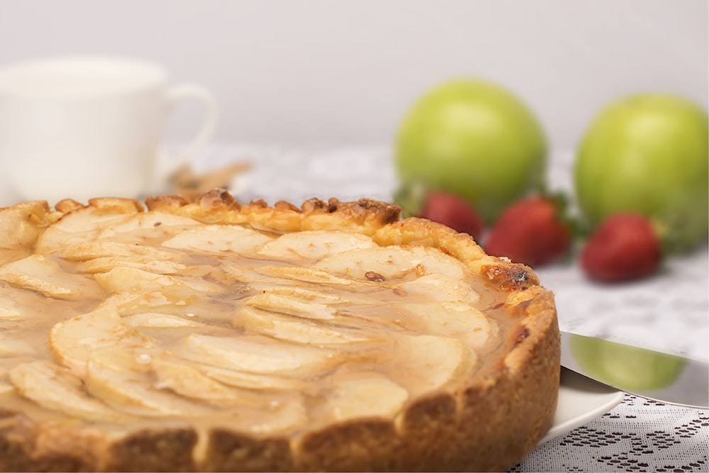 pie with cream on top near strawberry fruits