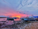Golden sunset over Pattaya beach with colorful boats resting on the shore