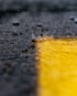 water droplets falling to yellow paint on gray surface