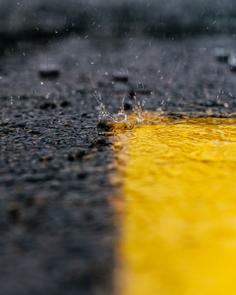 water droplets falling to yellow paint on gray surface