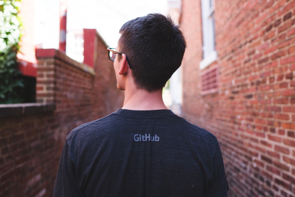 man wearing t-shirt and eyeglasses standing and facing back