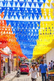 A vibrant printed banner hanging at a busy street corner in Bogotá.