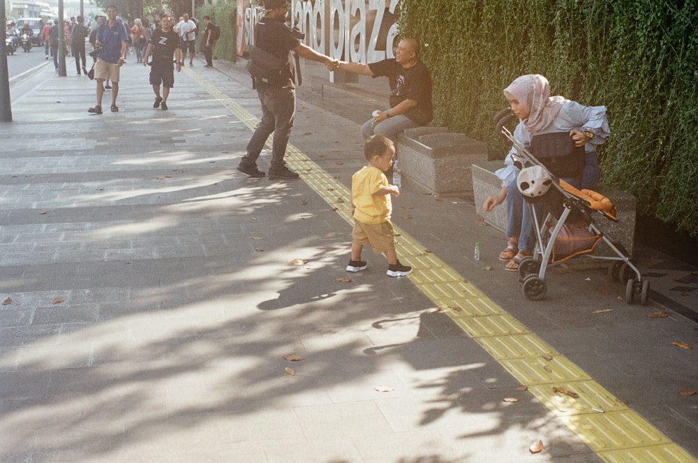 bambino che cammina sul marciapiede in cemento
