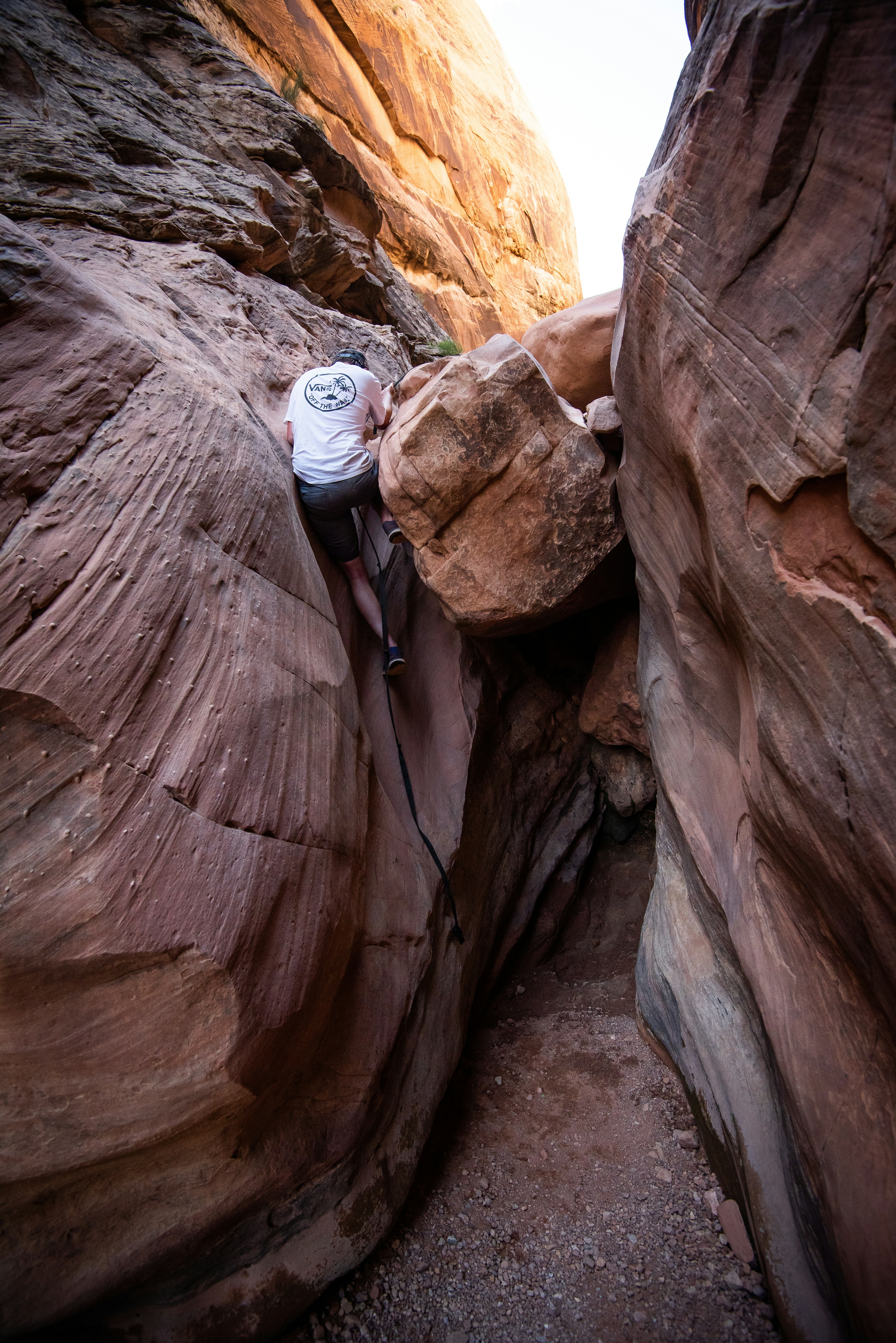 man climbing on brown rock formation during daytime