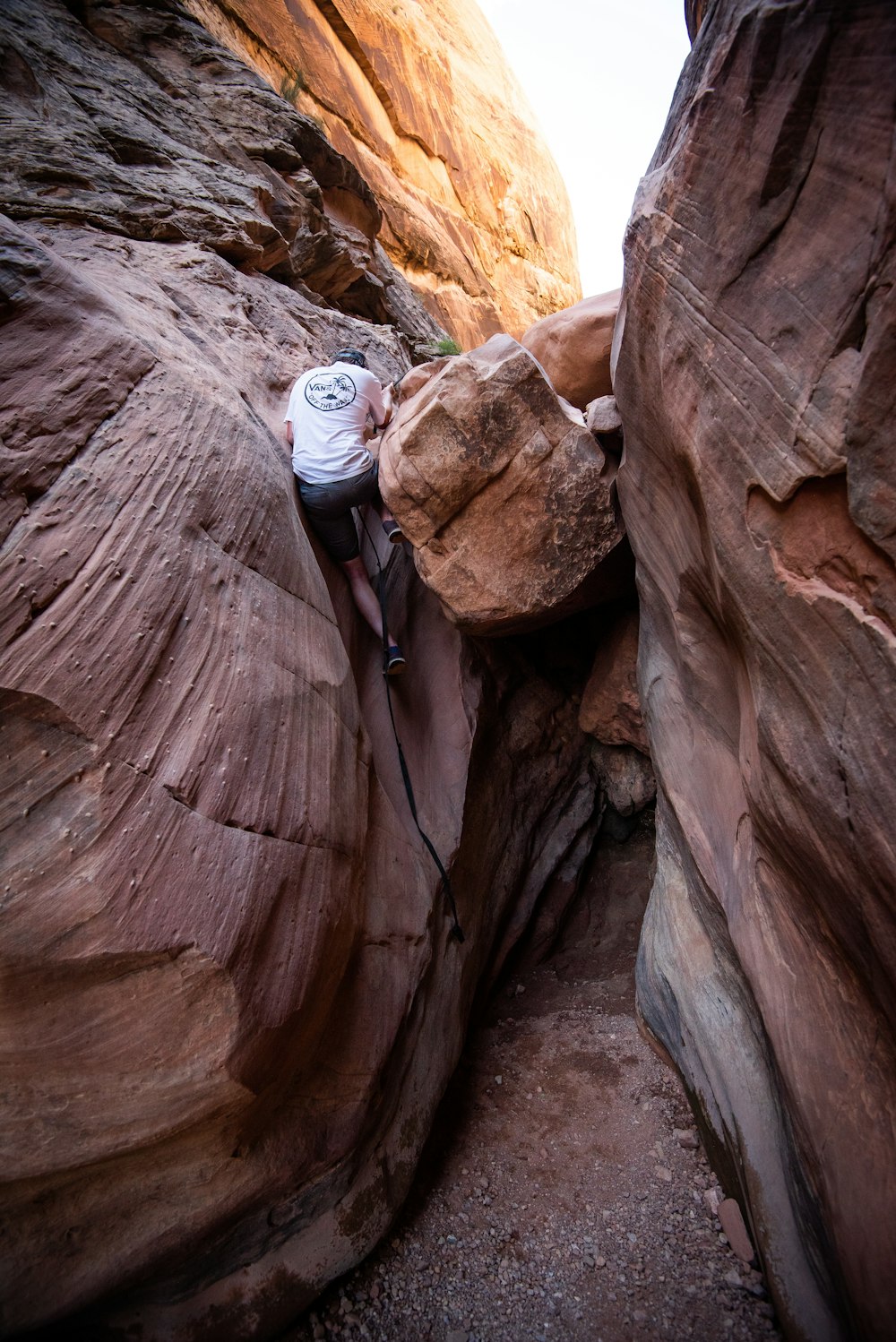 Hombre escalando en la formación de roca marrón durante el día