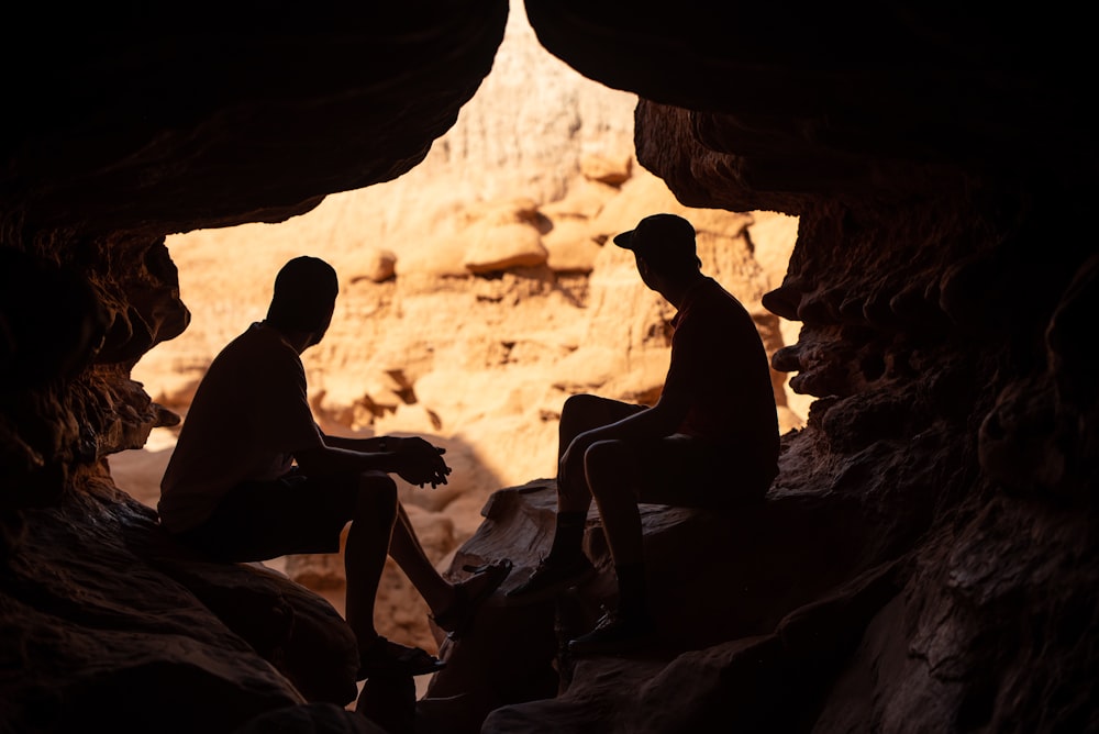 two person under a cave during daytime close-up photography
