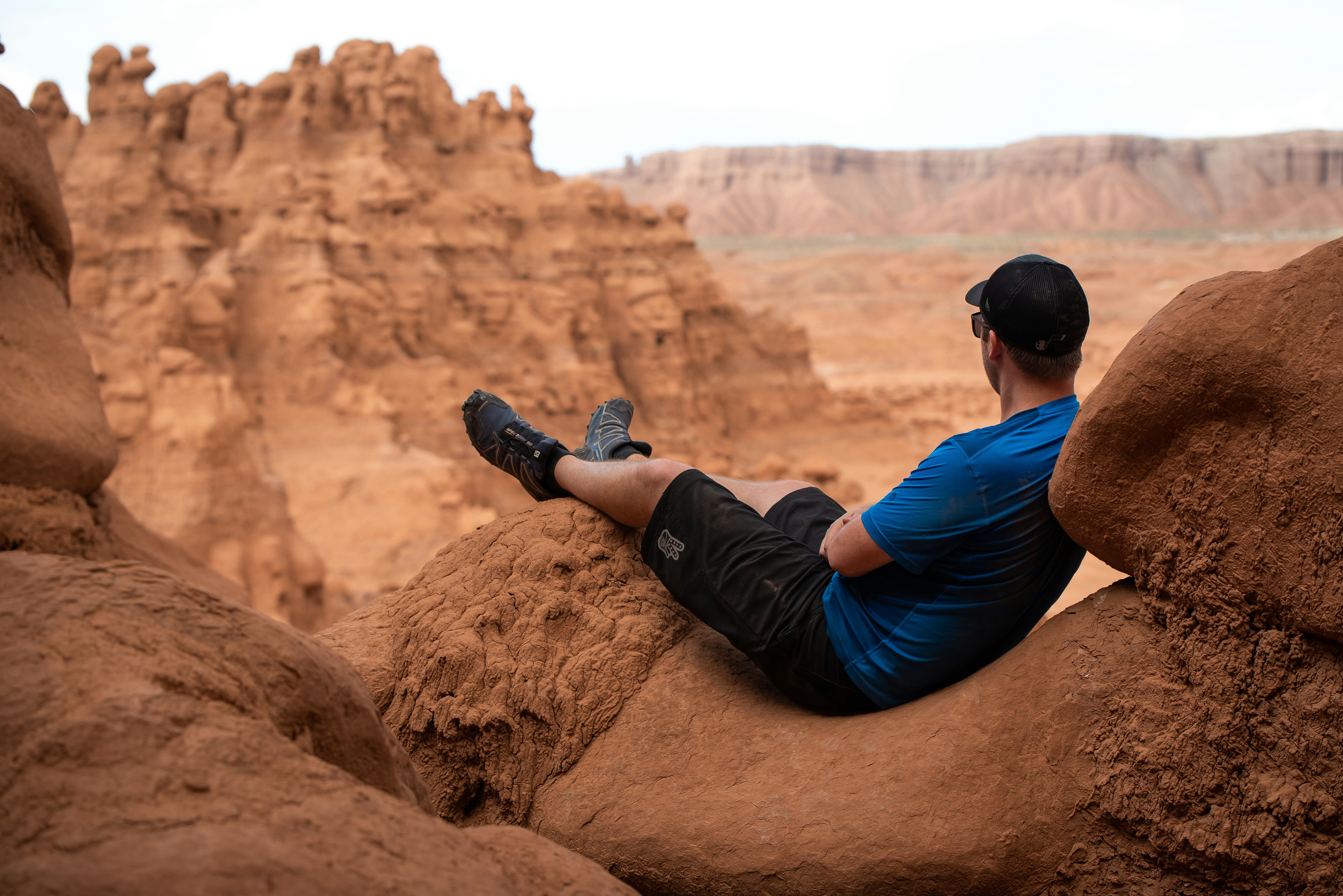낮에 갈색 암석에 앉아있는 남자