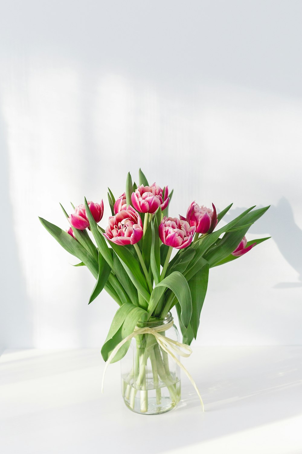 투명 유리 꽃병에 핑크 꽃잎 꽃 중앙 장식