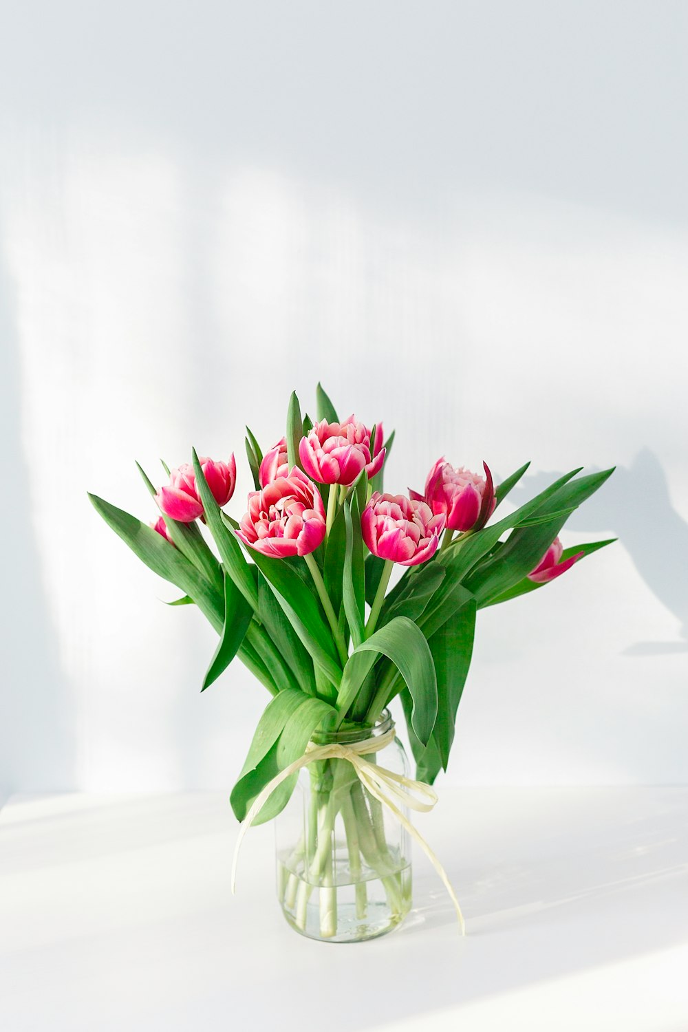 pink petaled flower centerpiece in clear glass vase