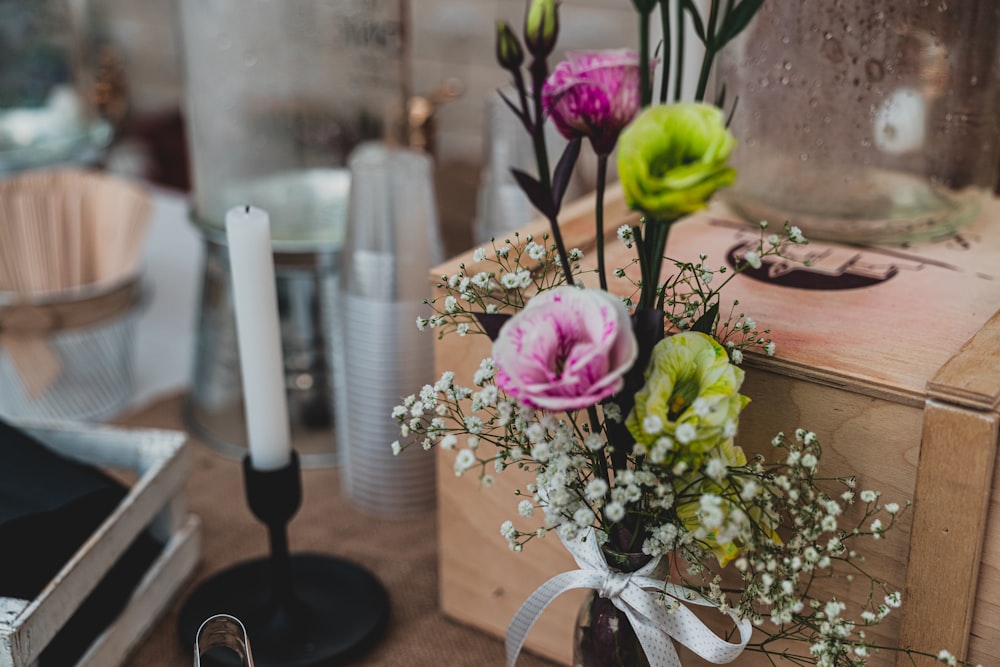 flower lot near a brown box and candle close-up photography\