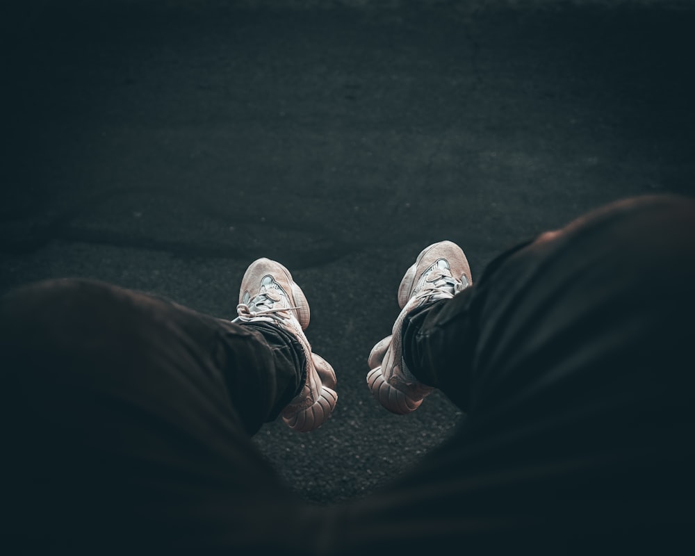 person wearing black pants and white sneakers