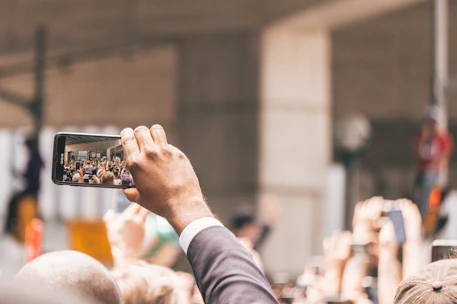 A passionate citizen journalist capturing a local event with a smartphone in a bustling city square.