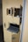 A yellow door with multiple small compartments and latches, featuring a sliding tray mechanism presumably for secure transactions or communications.