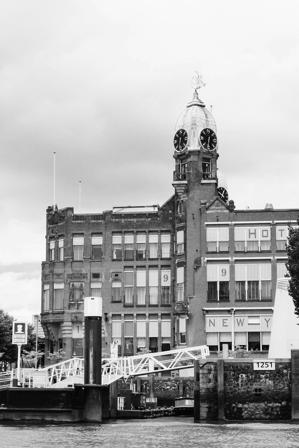 uma foto em preto e branco de um edifício com uma torre do relógio