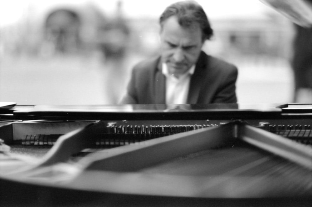 a man in a suit is playing a piano