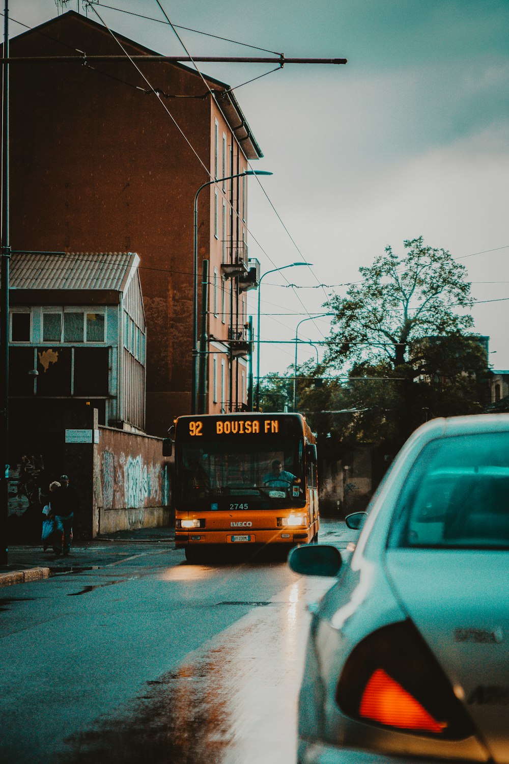 orange bus in road during daytime close-up photography