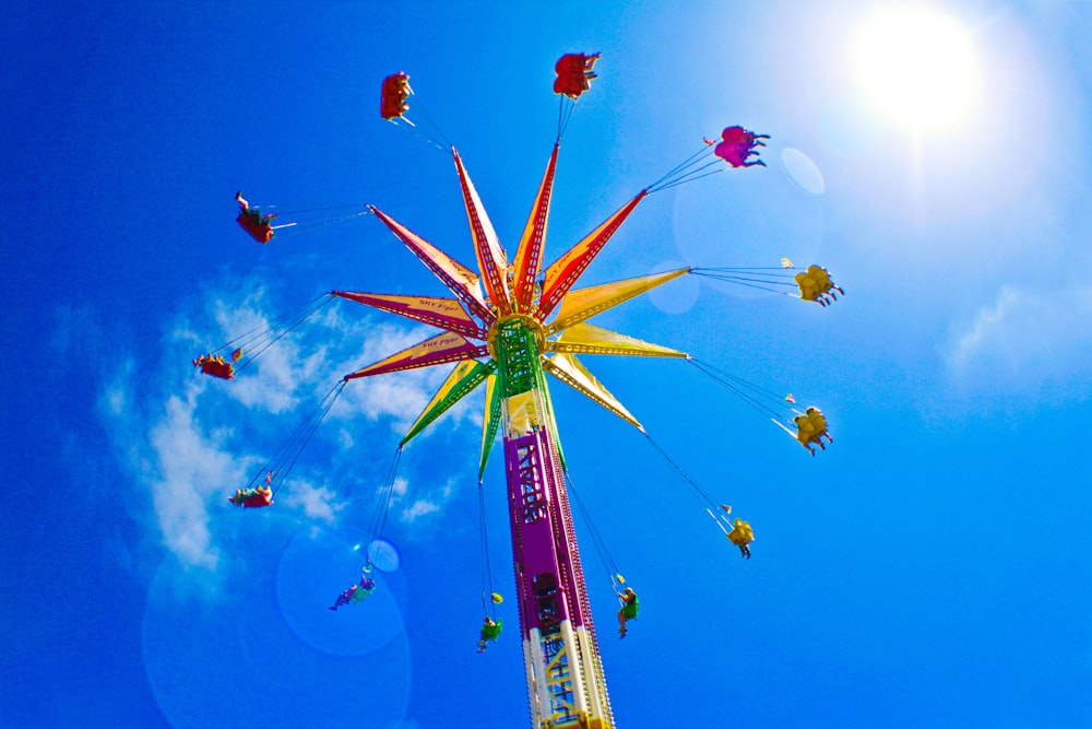 purple and multcolored amusement park ride during daytime