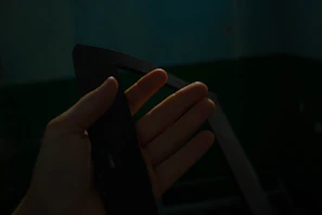 A collector’s hands holding a scarce promotional item against a dark, textured background