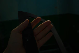 A collector’s hands holding a scarce promotional item against a dark, textured background