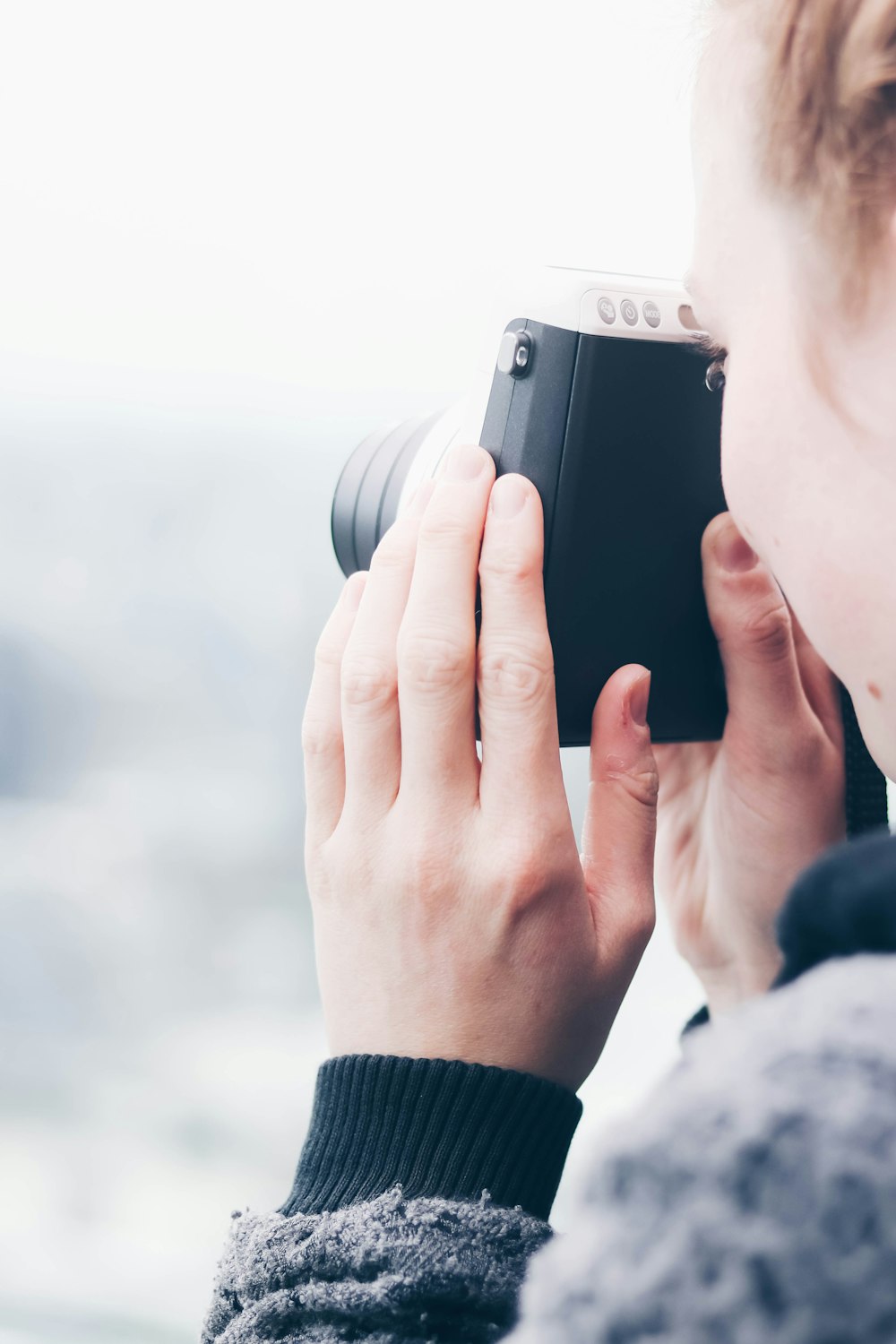 person holding a black camera during daytime