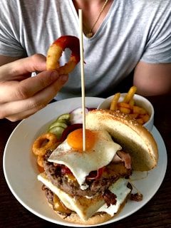 A gourmet burger with a side of onion rings.