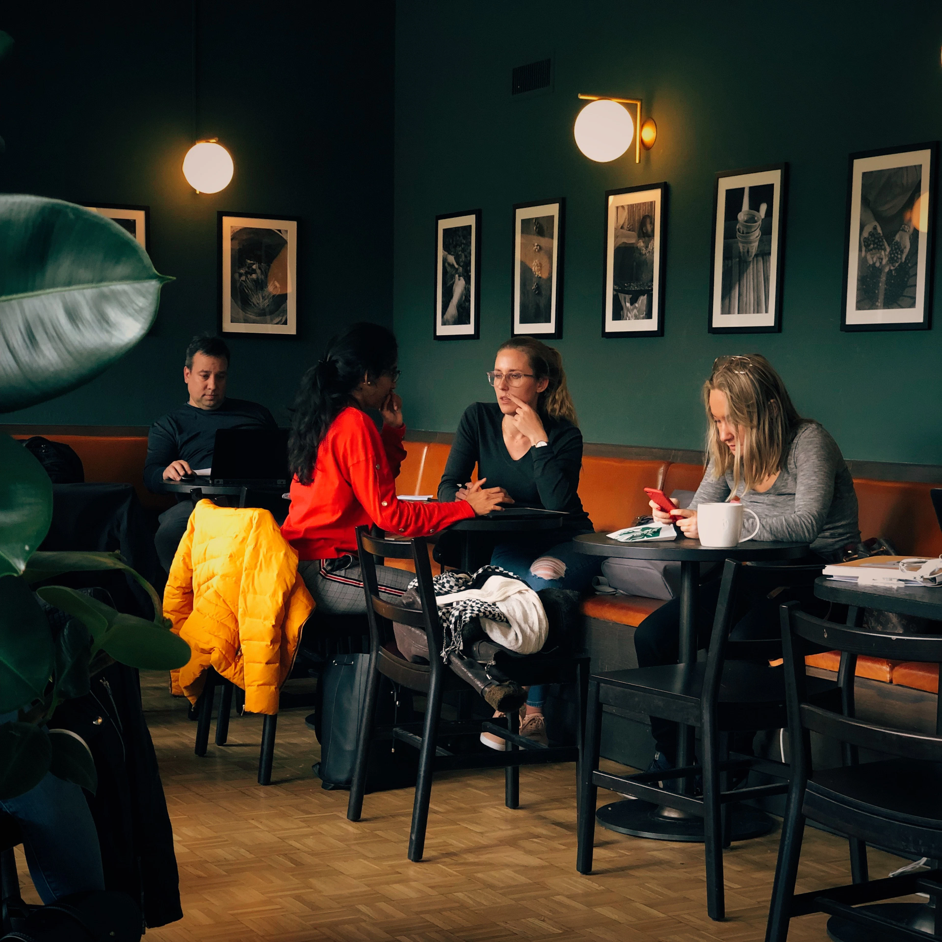 Friends gathered on a sofa under framed prints