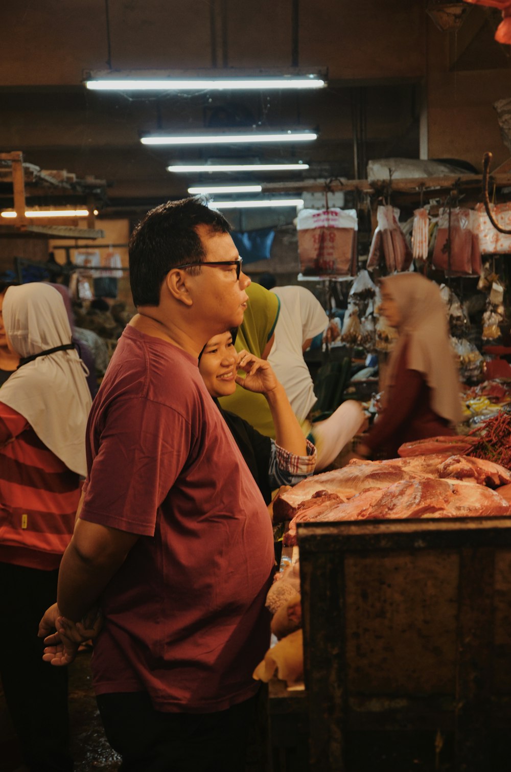 man standing in front of meat shop