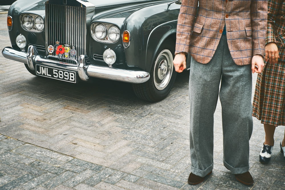 a man and a woman standing next to a car