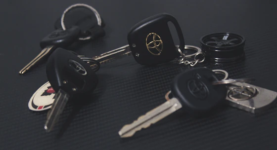 A set of freshly made car keys laid out on a wooden workbench.