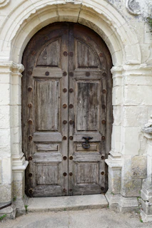 A weathered wooden double door with ornate hardware
