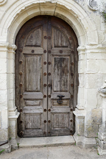 A weathered wooden double door with ornate hardware