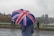 person holding blue, white, and red umbrella