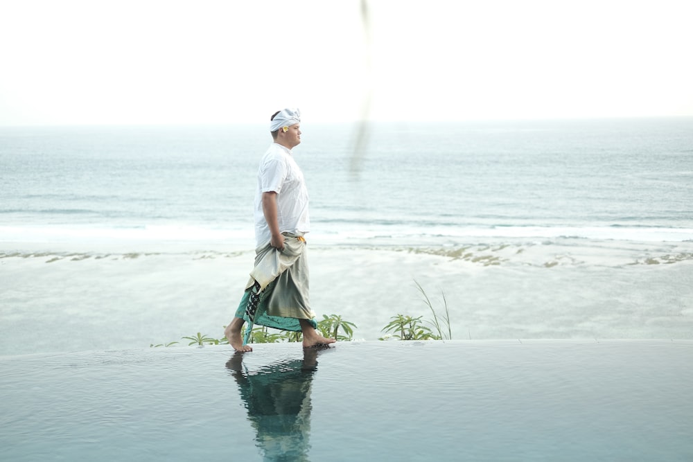 Hombre caminando en la orilla del mar durante el día