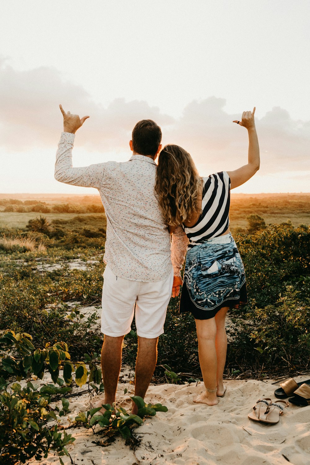 man and woman standing on white sand