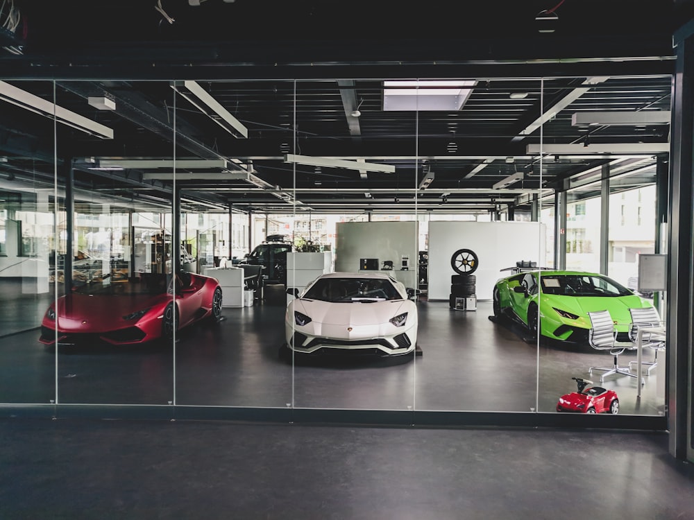 three white, red, and green Lamborghini coupes