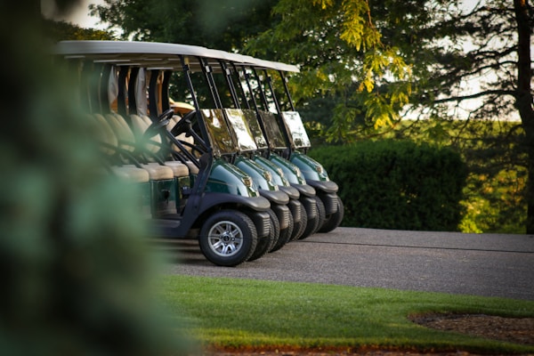 Golf carts on a course pathway, showcasing powered golf transport options