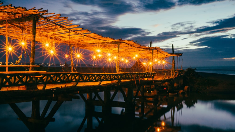 brown wooden dock with lights during nighttime