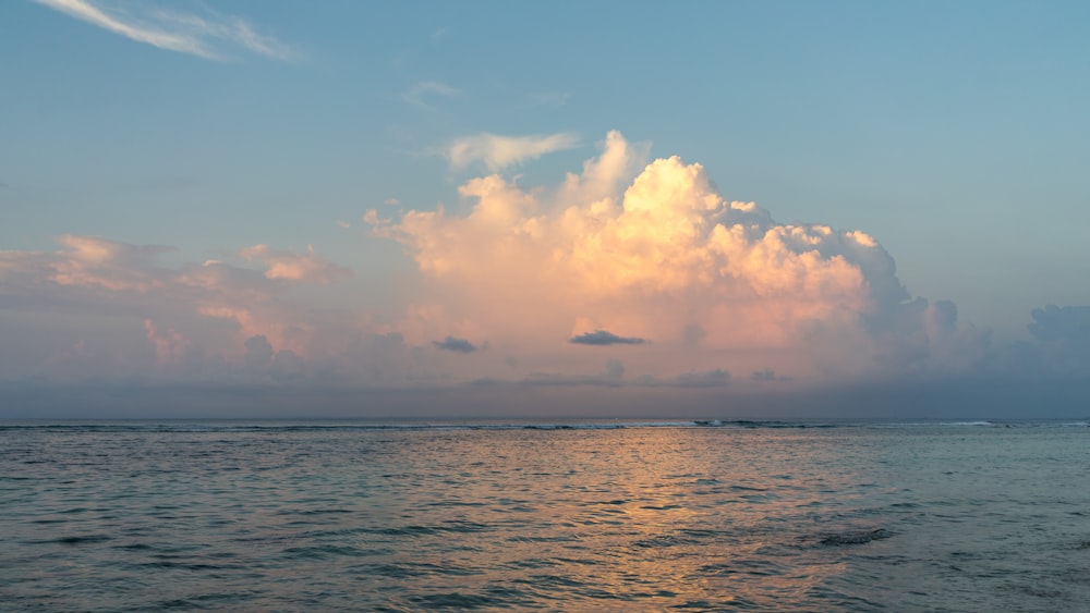 body of water under blue and white sky at daytime