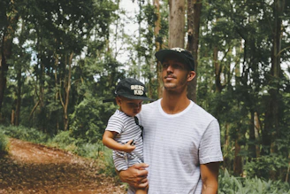man carrying child inside forest