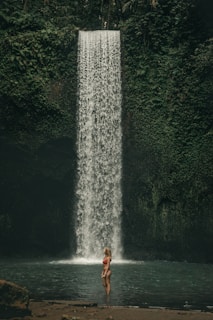 woman standing near waterfall during daytime