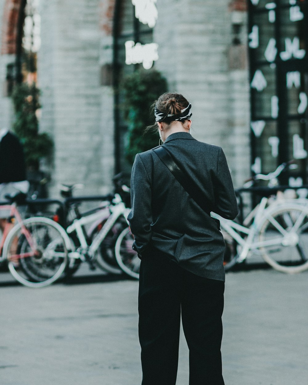 woman wearing black jacket walking on street