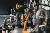 Close-up of hands working on detailed mechanical piping for heating systems.